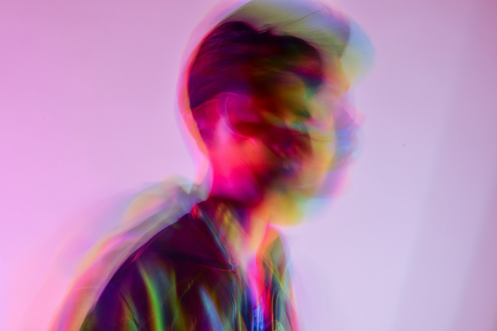 Futuristic motion-blurred portrait lit with iridescent light, representing intuitive human-centered interfaces